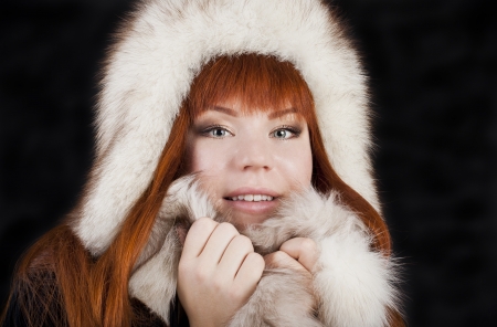 Beautiful red-haired girl in a fur hatの写真素材