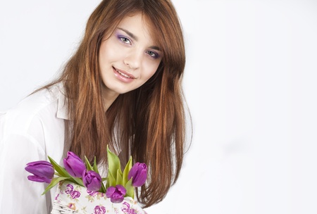 Beautiful girl with bunch of spring flowers isolated on white backgroundの写真素材