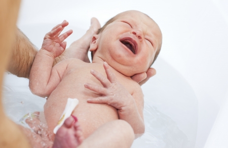 newborn is bathed in the bathroomshouts and criesの写真素材