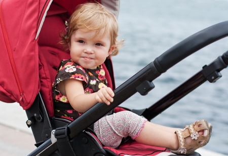 smiling baby in a stroller in the background of the seaの写真素材