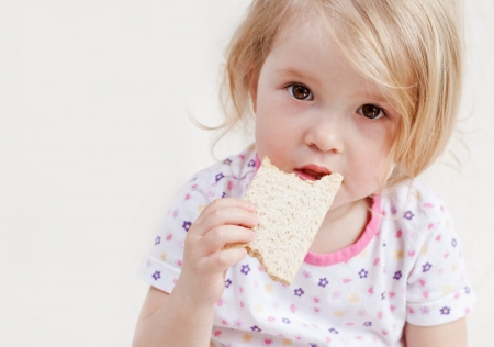 cute baby eats bread on a white backgroundの写真素材