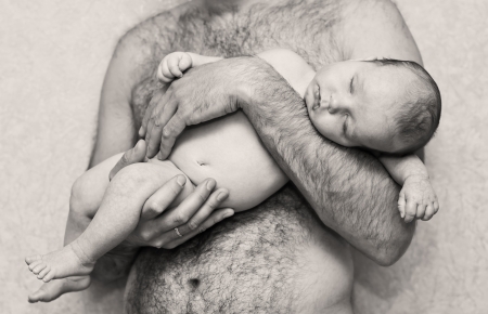 baby sleeps in his father's armsの写真素材