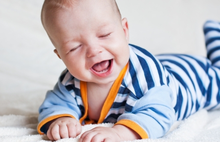 Happy little baby laughing with eyes closedの写真素材