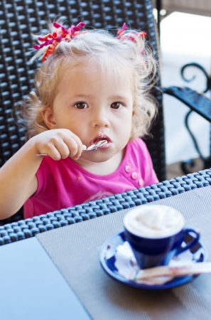 funny toddler girl in cafe looking at the cameraの写真素材