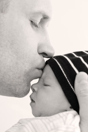 happy father kissing baby son on a white backgroundの写真素材