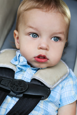 Portrait of a cute toddler boy sitting in the car seatの写真素材