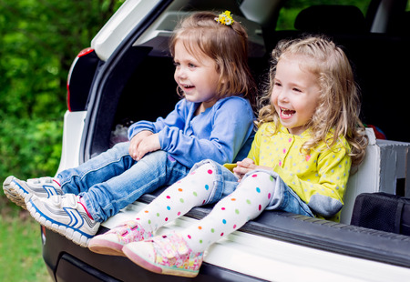 two happy kids in the carの写真素材