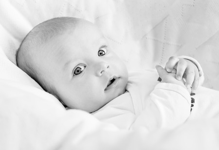 cute newborn baby smiling looking at the camera ( black and white )