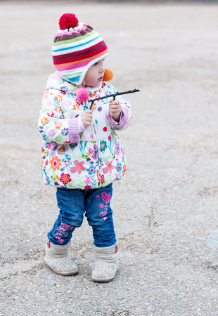 Toddler girl playing on a walk in autumnの写真素材