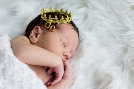 Portrait of a newborn baby boy with a golden crownの写真素材