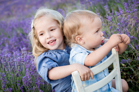 happy little brother and sister playing in the lavender fieldの写真素材