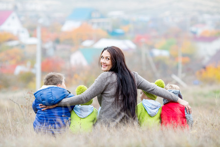 Happy mother with small children walking in autumnの写真素材