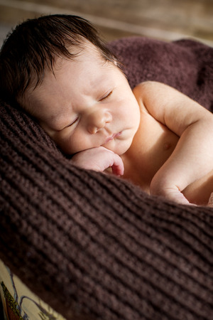 portrait cute newborn baby sleeping on brown blanketの写真素材