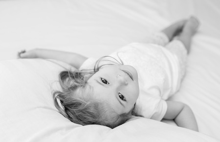 Adorable smiling little girl waked up in her bed ( black and white )の写真素材