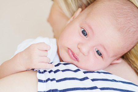cute newborn boy on the shoulder of mother