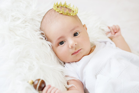 Portrait of a newborn baby boy with a golden crownの写真素材