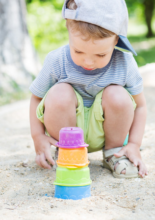 Toddler boy playing in the sand in the summerの写真素材