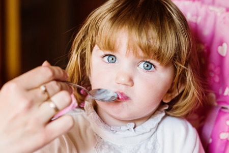 Mother breast feeding her daughter Toddler porridgeの写真素材