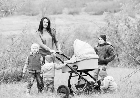 Happy mother with small children walking in autumn  ( black and white )
