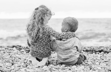 cute little brother and sister playing on the beach (  black and white )の写真素材