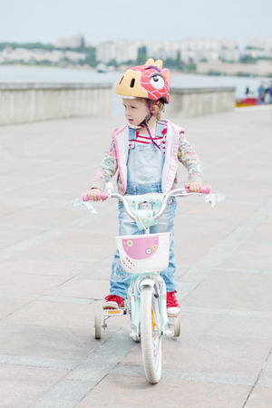 Little girl riding a bike on the waterfrontの写真素材