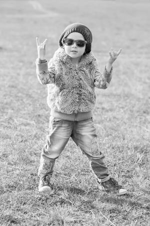 cute little girl making a rock-n-roll sign outdoors ( black and white )の写真素材