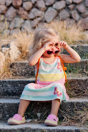 Toddler cute little girl in glasses at sunsetの写真素材