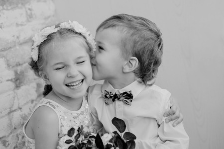 Happy little children embrace and kiss on a light background  ( black and white )の写真素材