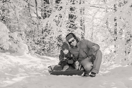 Happy Toddler boy with dad in the snowy forest outdoors  ( black and white )の写真素材