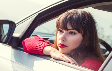 attractive young woman driving a car on a sunny dayの写真素材