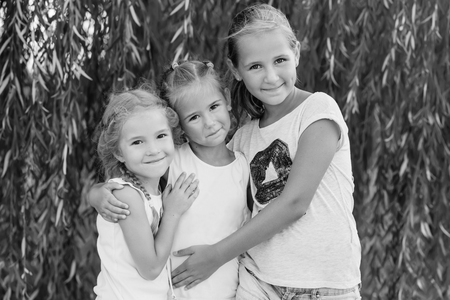 portrait of three young cousins on willow background in summer ( black and white )の写真素材