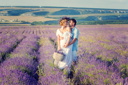 Happy pregnant couple in a lavender fieldの写真素材