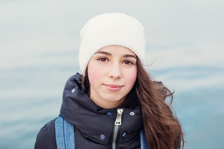 Portrait of kid girl on sea background, outdoors in spring time