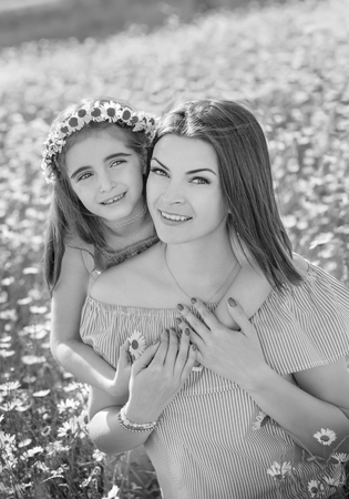 Mother and daughter in  field of daisies. Beautiful family in nature ( black and white )の写真素材