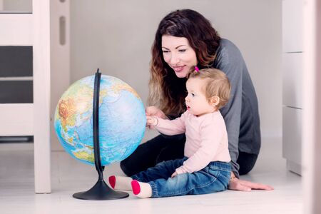 Mom and her curious little baby are researching the globe while spending time in the together