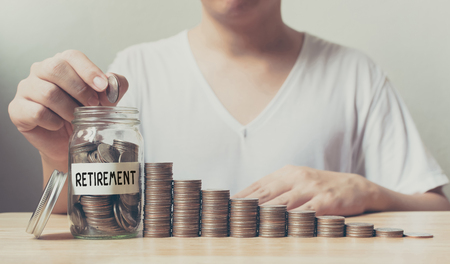 Hand putting coins in jar word retirement with money stack step growing growth saving money, Concept finance business investmentの写真素材