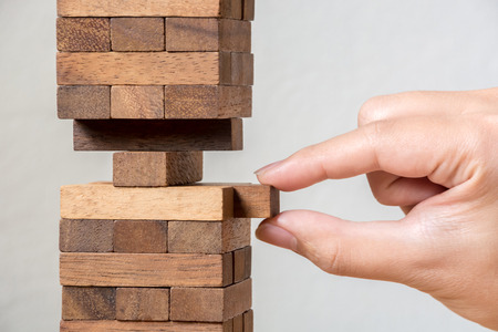 Hand putting wood block stack tower, Concept risk managementの写真素材