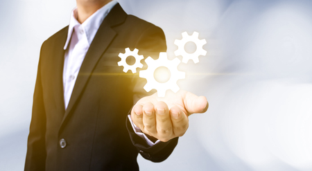 Businessman hand holding gear icon, Business internet connection to successful conceptの写真素材