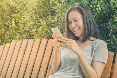Asian young woman hand holding mobile phoneの写真素材