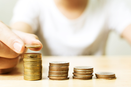 Hand of male putting gold coin stack step up growth, Financial investment and save money conceptの写真素材