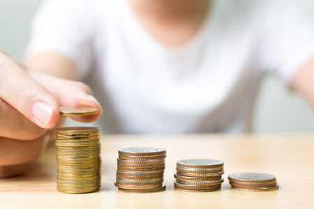 Hand of male putting gold coin stack step up growth, Financial investment and save money conceptの写真素材