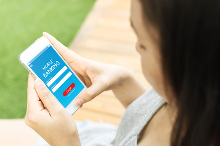 Asian female hand holding mobile phone and using application mobile banking loginの写真素材