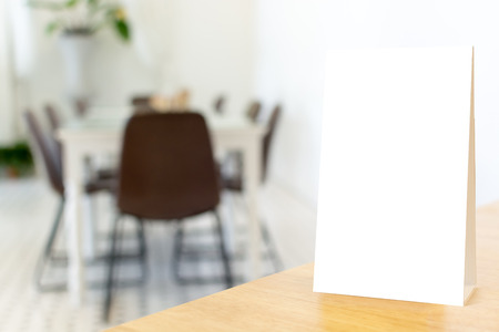 Mock up blank template menu frame on wood table in restaurant with blurred background, Clipping path includedの写真素材