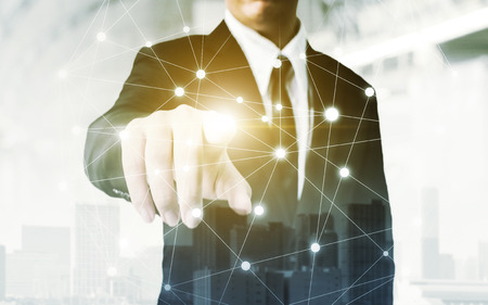 Network and Connection technology concept, Double exposure of businessman hand touching world map point with building in the cityの写真素材