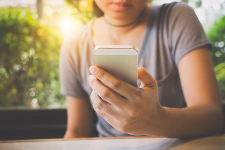 Asian woman hand holding mobile phone and using application on smartphoneの写真素材