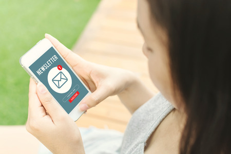 Woman hand holding mobile phone and use email application, Subscribe newsletter conceptの写真素材