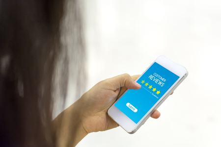 Customer review rating business concept, Woman hand using mobile phoneの写真素材