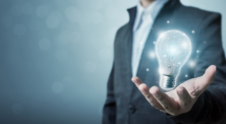 The power of creativity, technology, innovation or new business to success in the future concept, Businessman holding light bulbの写真素材