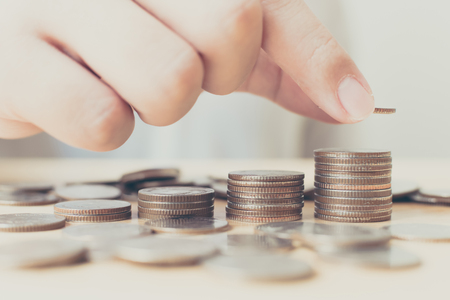 Saving money for investment concept, Hand of male or female putting coin stack step growing growth financialの写真素材