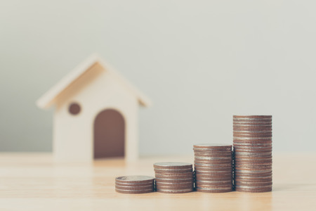 Property investment and house mortgage financial concept, Money coin stack with wooden house